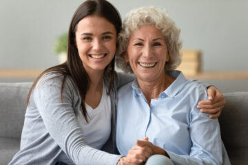 Elderly-grandmother-adult-granddaughter-sitting-on-couch-posing-for-camera-nursing-home-sell-moms-house Bridgetown Home Buyers